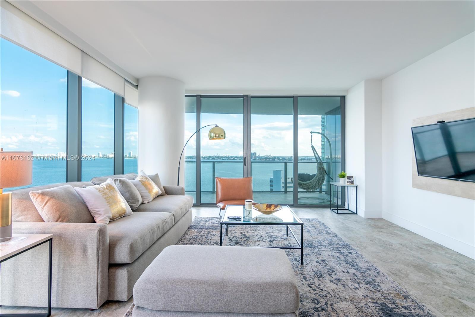 a living room with furniture and a floor to ceiling window