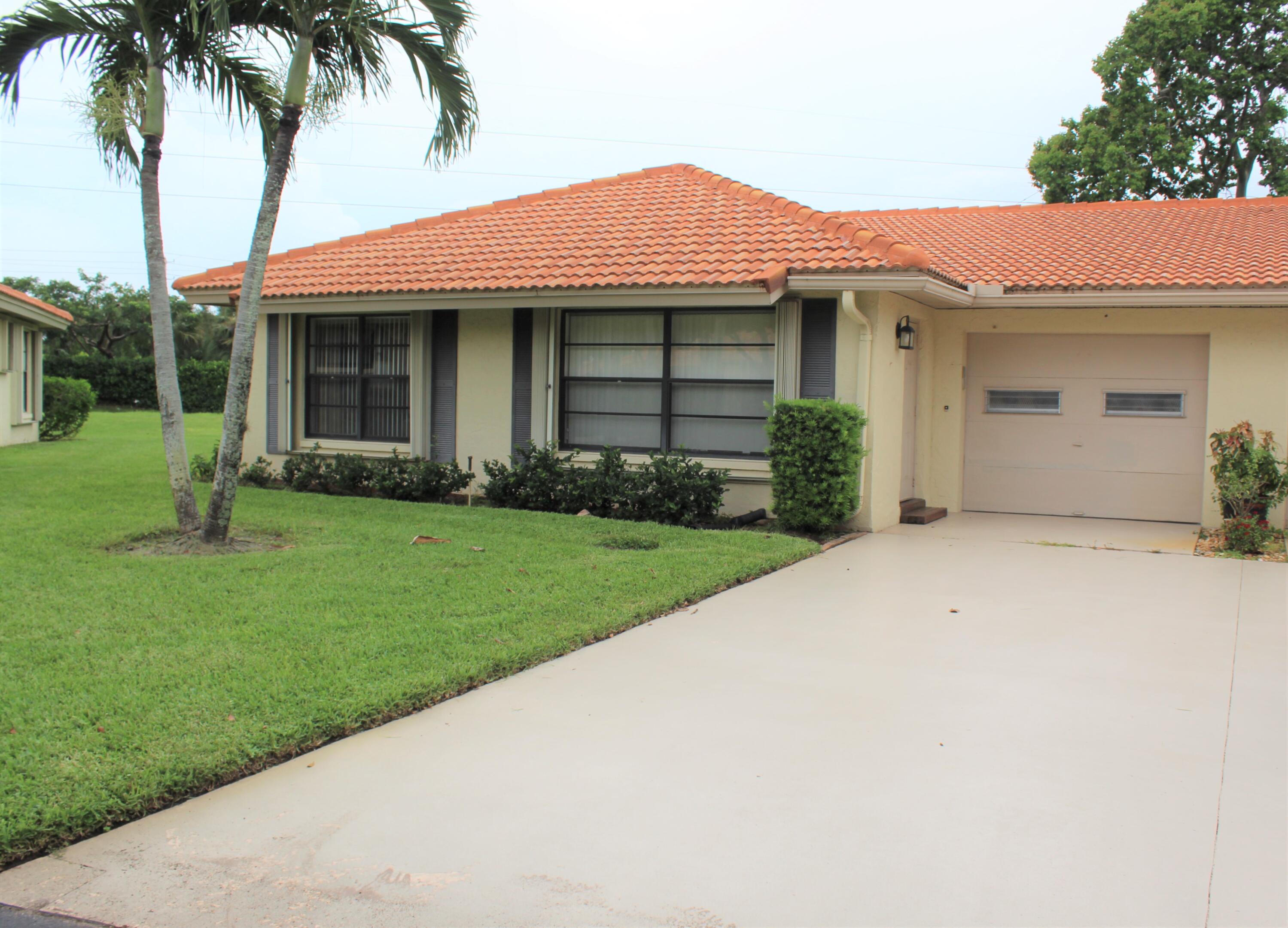 a front view of a house with a garden and yard