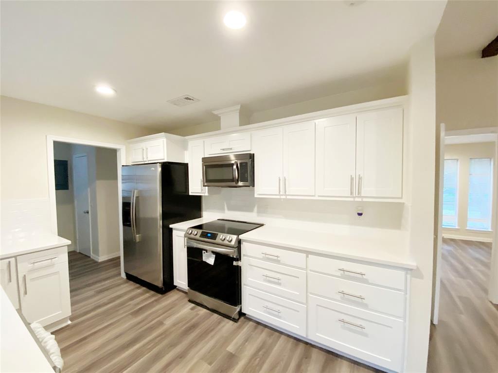 a kitchen with stainless steel appliances a stove a refrigerator and cabinets