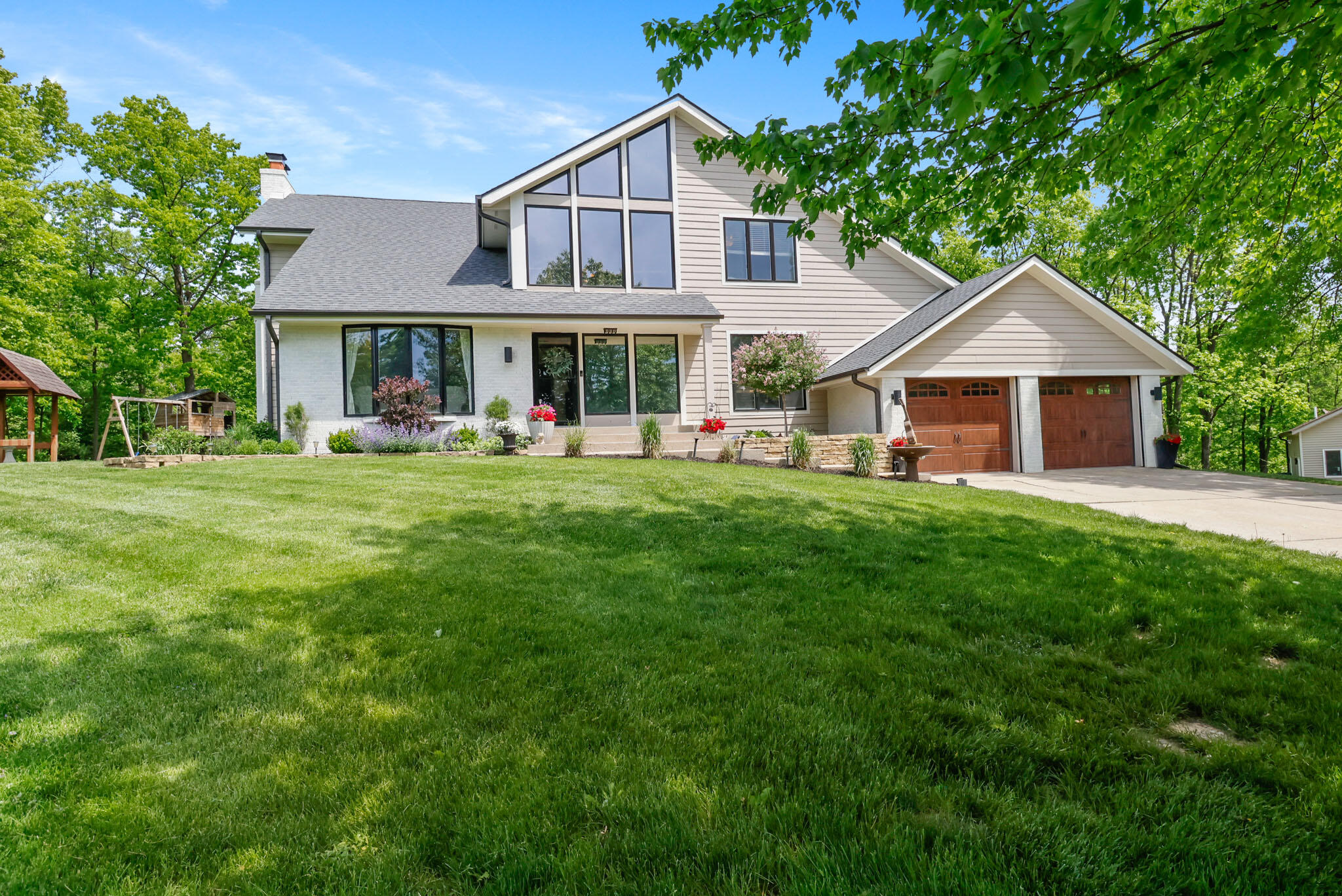 a front view of a house with a garden and trees