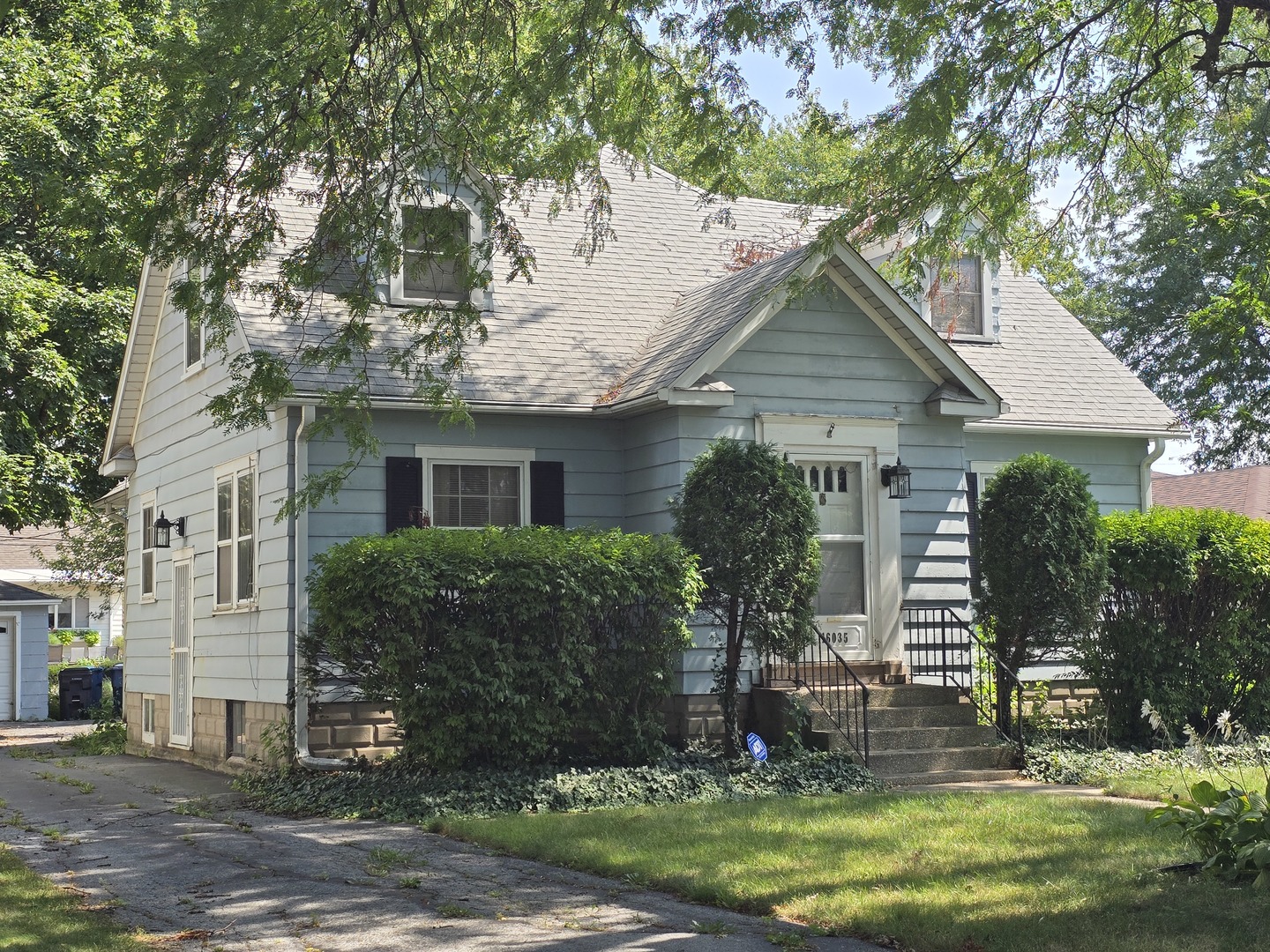 a front view of a house with a garden and plants