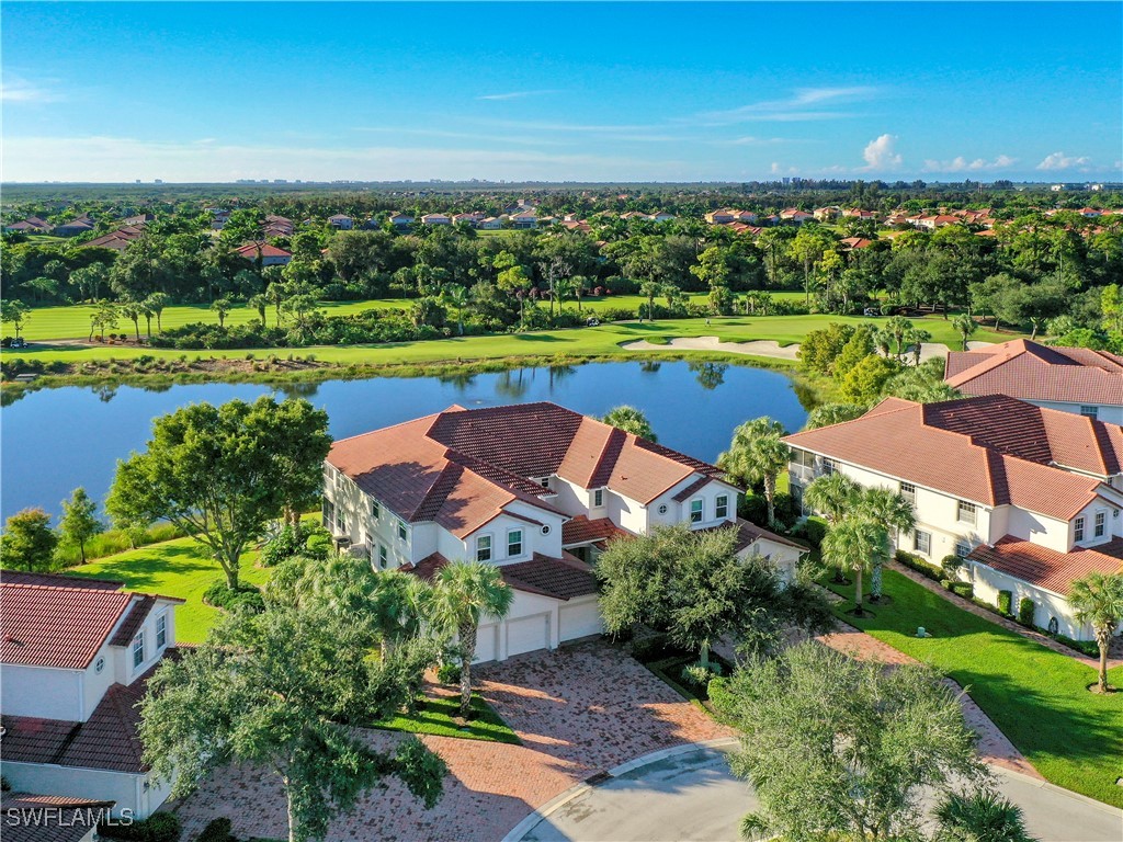 an aerial view of a houses with a garden and lake view