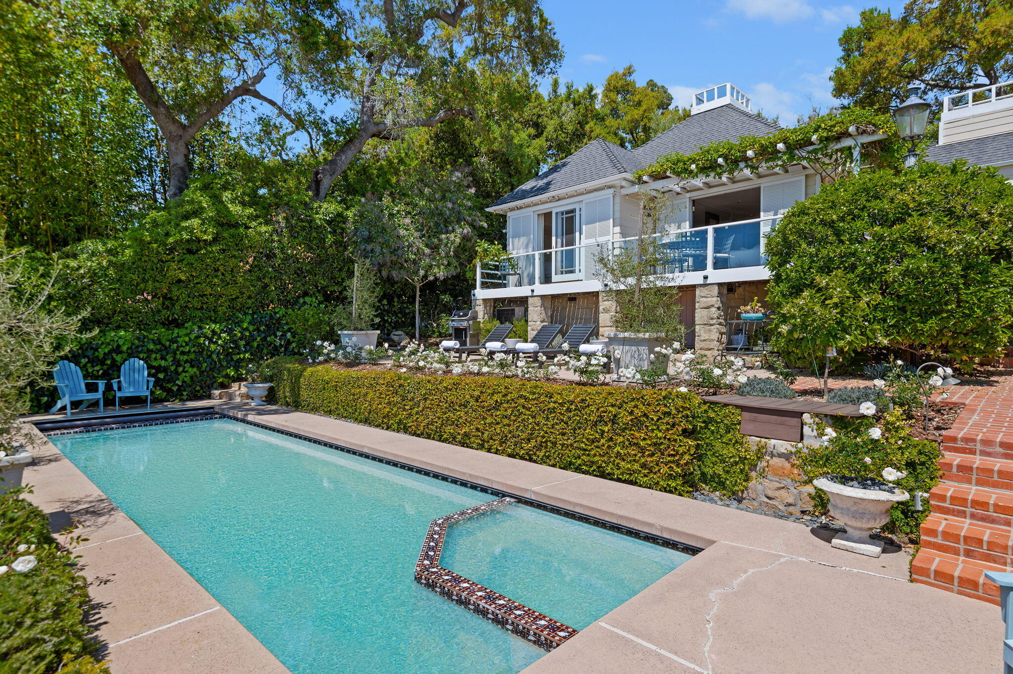 a view of a house with swimming pool lawn chairs and a yard