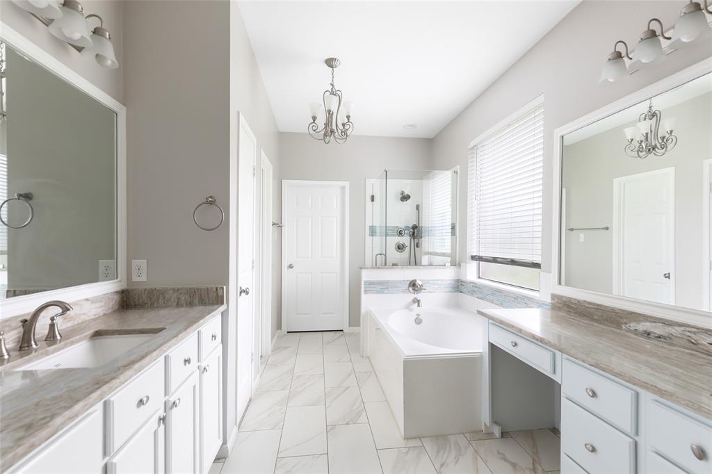 Updated primary bathroom with granite, flooring, new tile, and new lighting