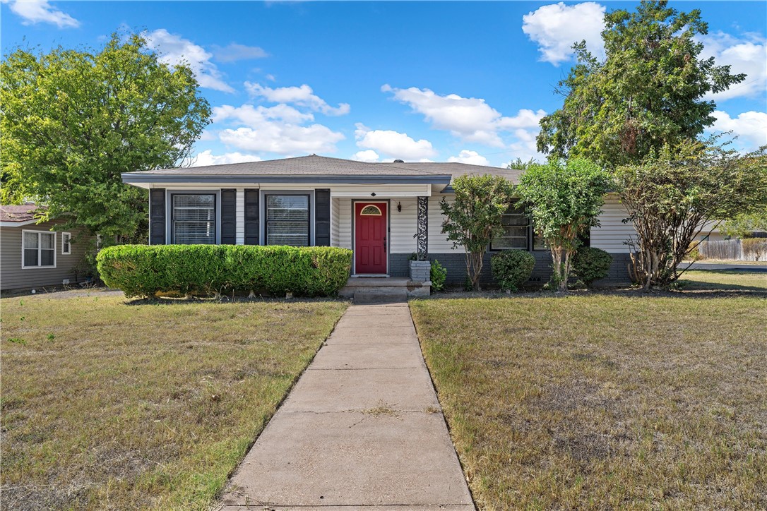 a front view of a house with a yard and potted plants