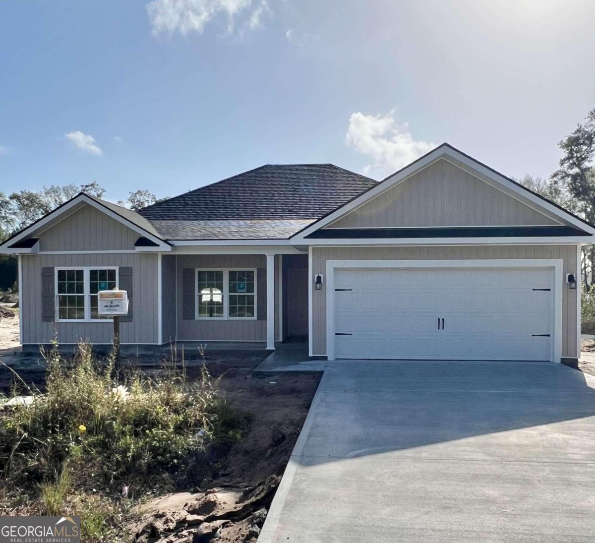 a front view of house with yard and trees around