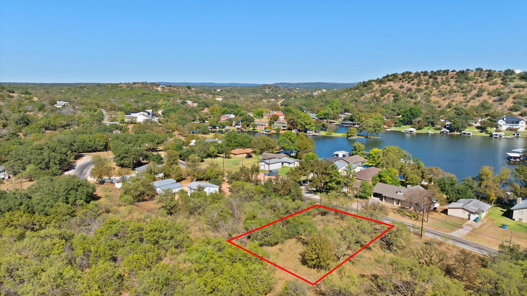 an aerial view of residential houses with outdoor space and lake view