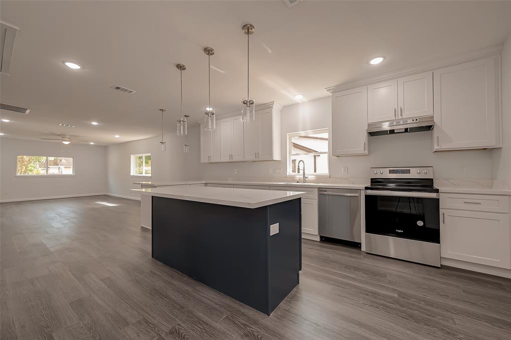 a kitchen with stainless steel appliances granite countertop a stove a sink and a refrigerator