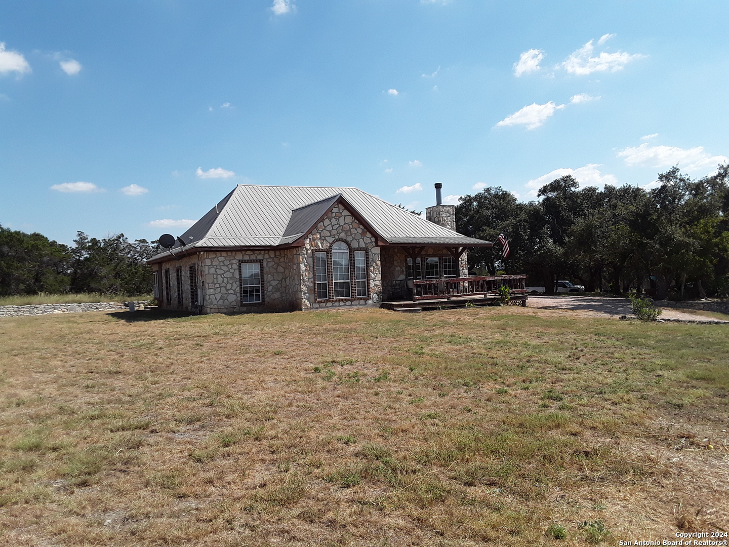 a front view of house with yard and trees in the background