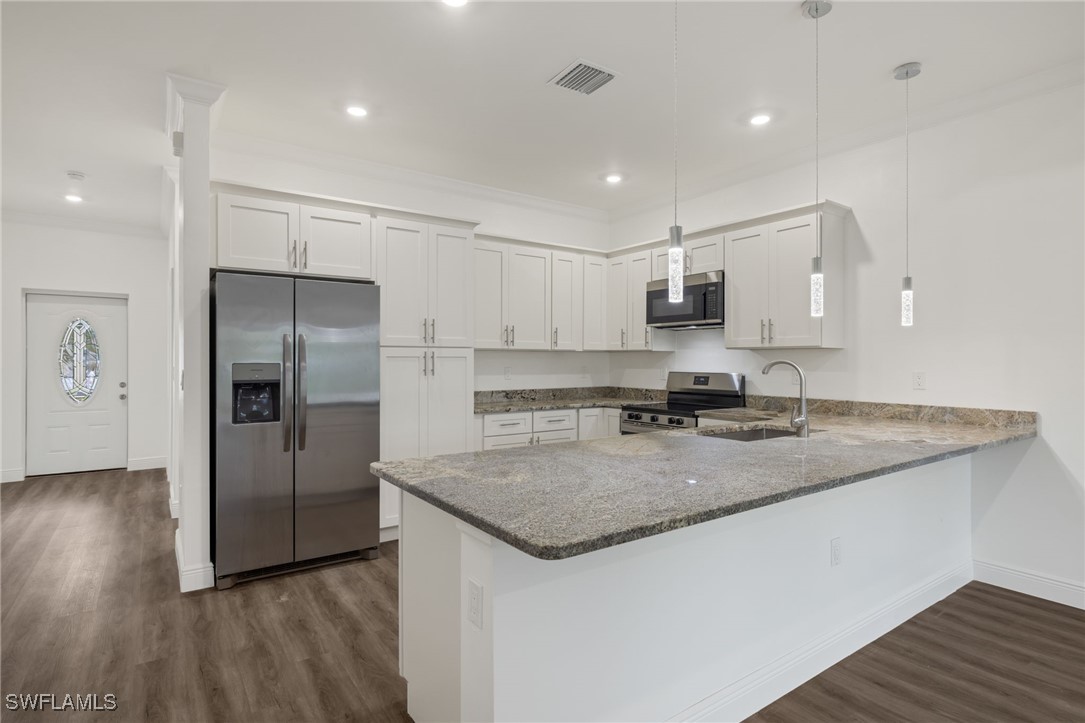 a kitchen with a refrigerator a sink and wooden floor