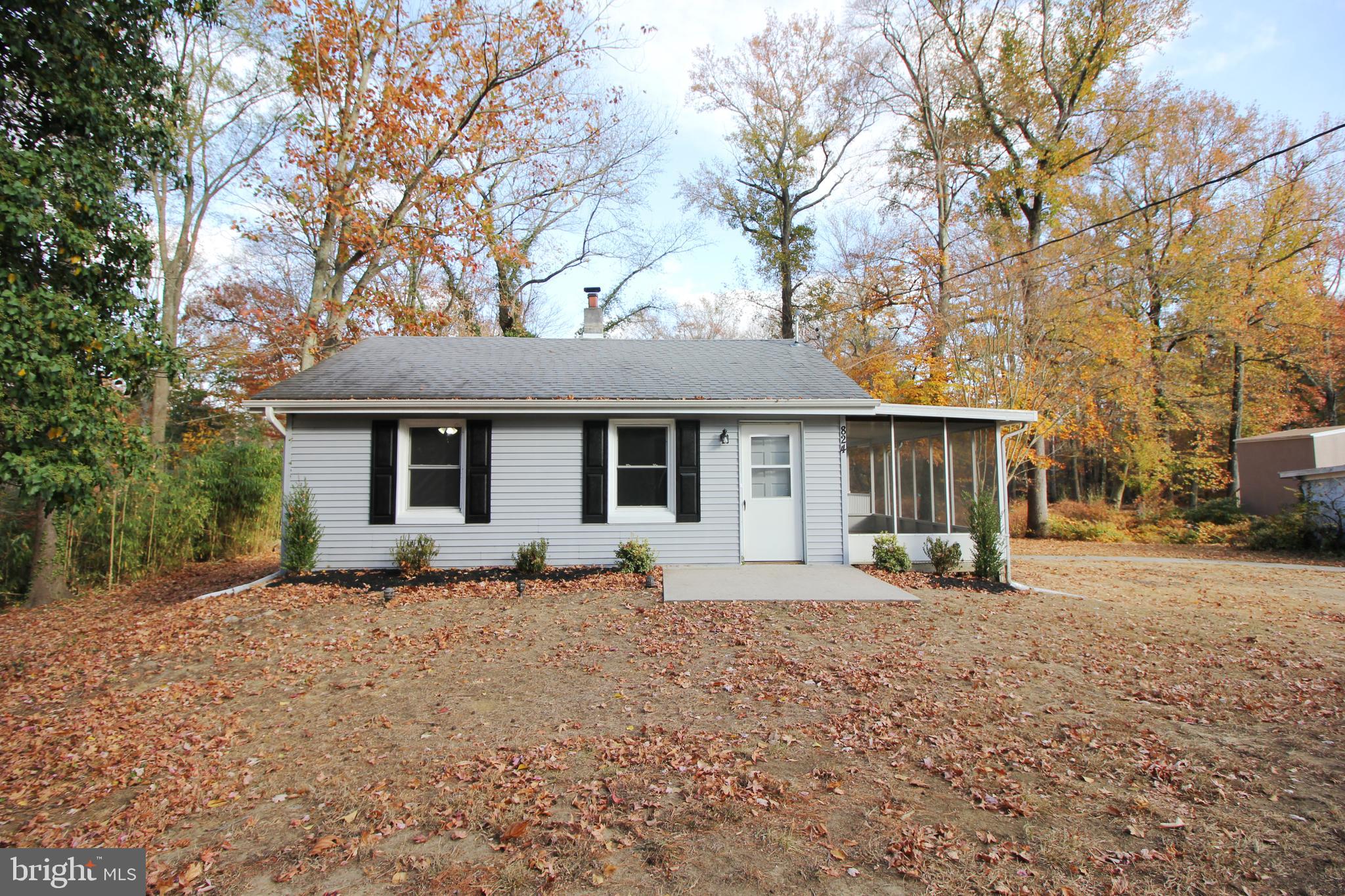 a front view of a house with a yard and trees