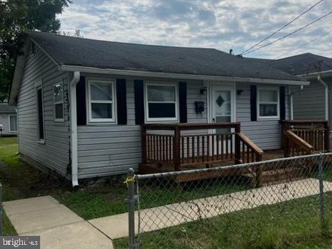 a view of a house with a small yard and wooden fence