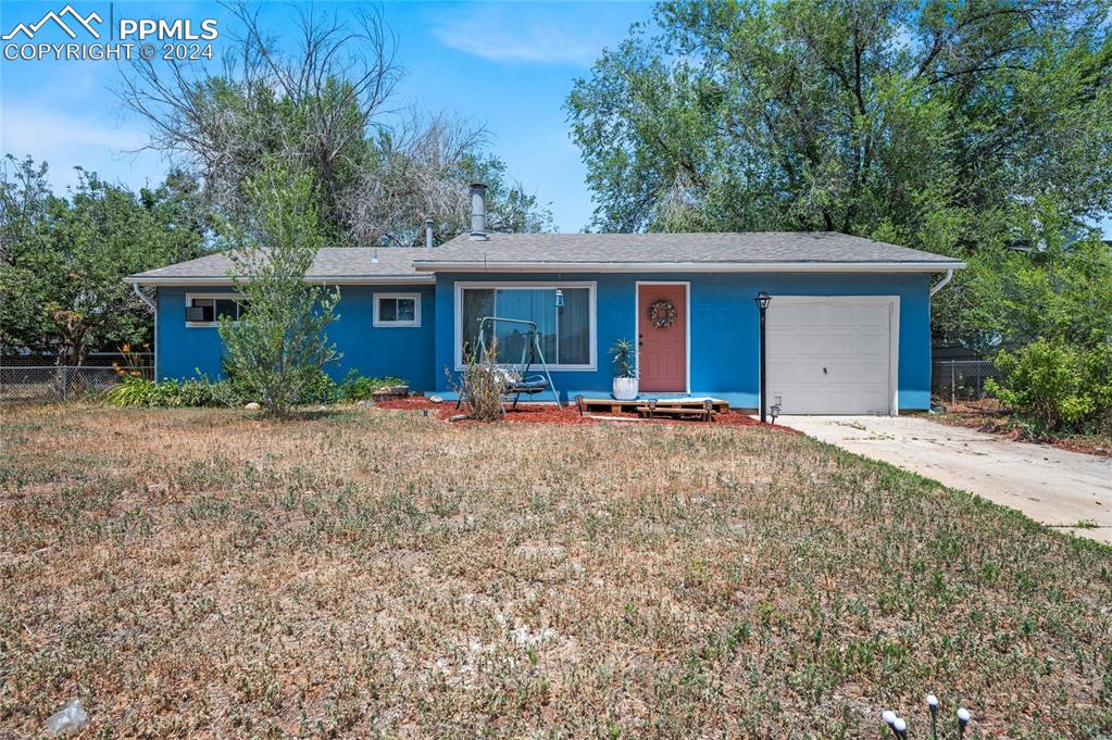 Ranch-style house with a garage and a front lawn