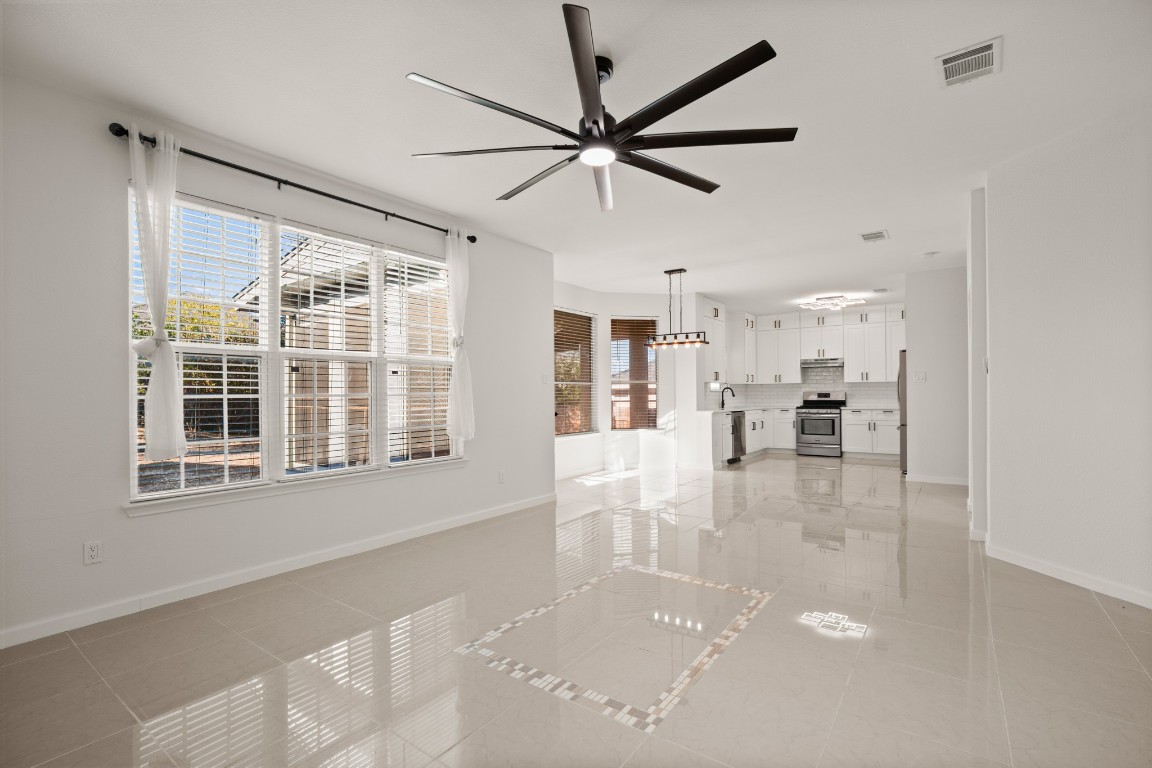 a view of a livingroom with a furniture a ceiling fan and window