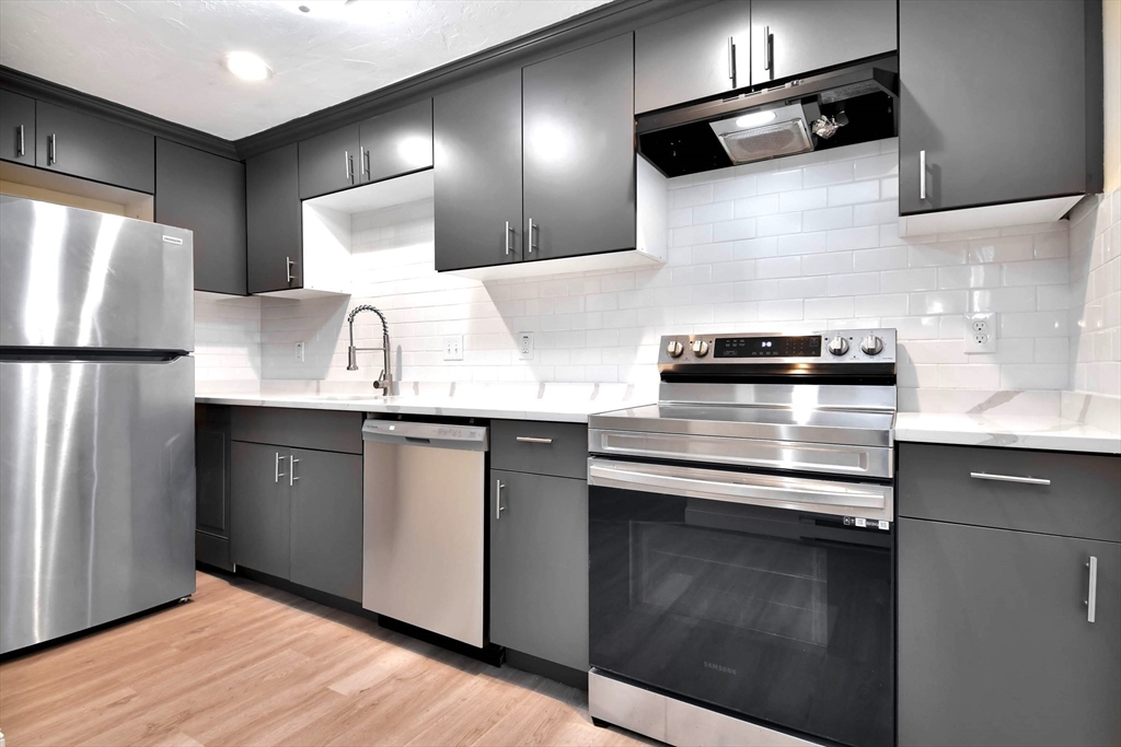 a kitchen with stainless steel appliances a sink and a refrigerator