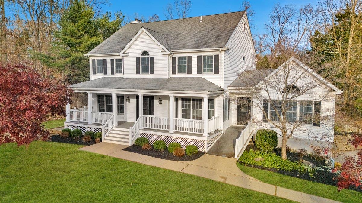 View of front of house with covered porch and a front yard