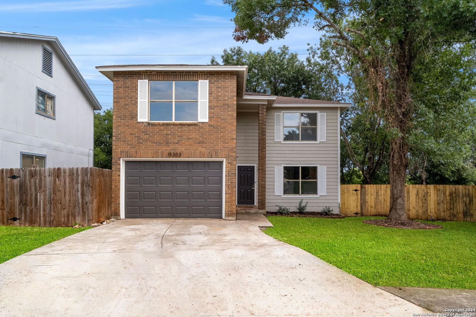 a front view of house with yard and trees in the background