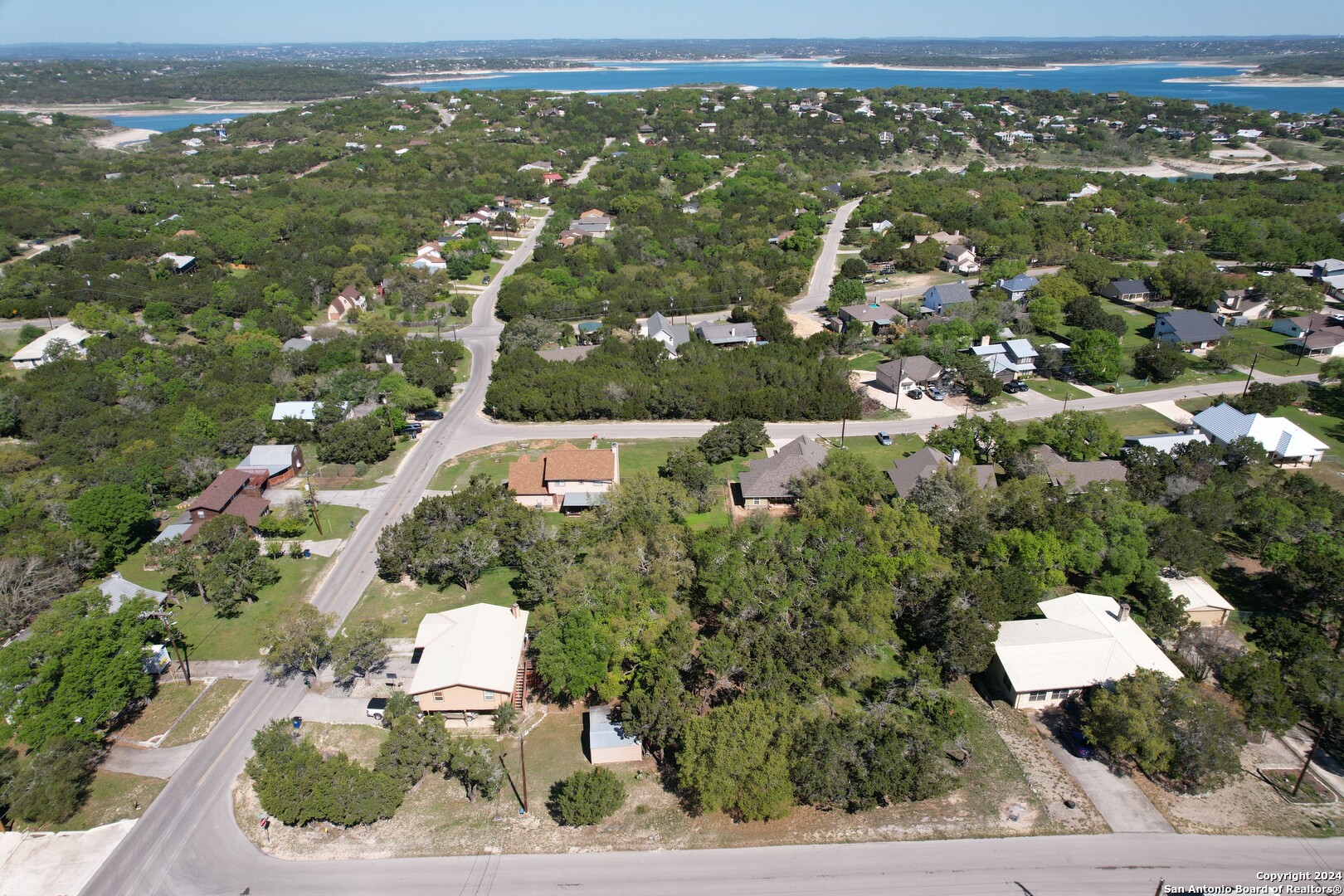 an aerial view of residential houses with outdoor space and trees