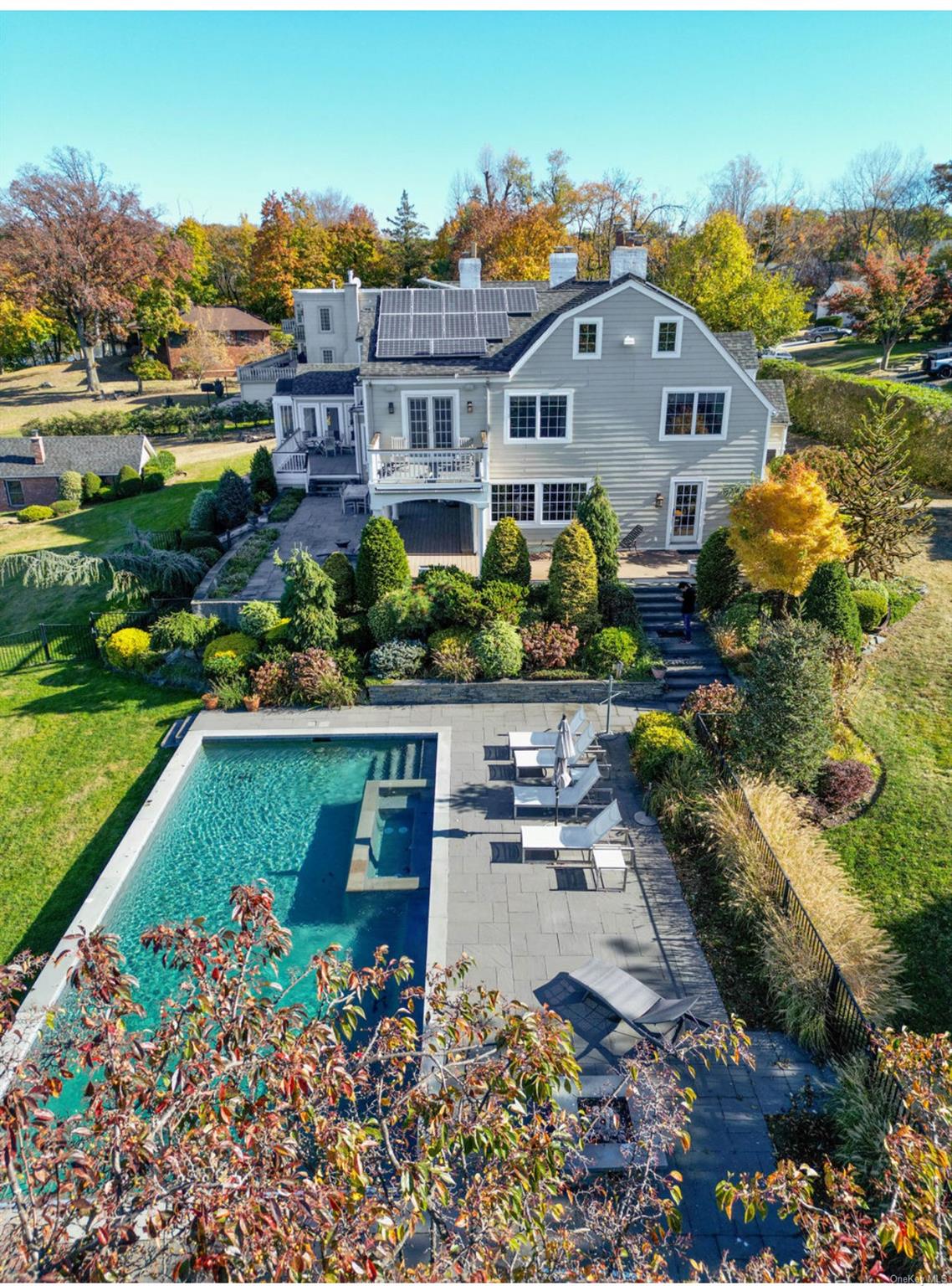 an aerial view of a house with a garden and lake view