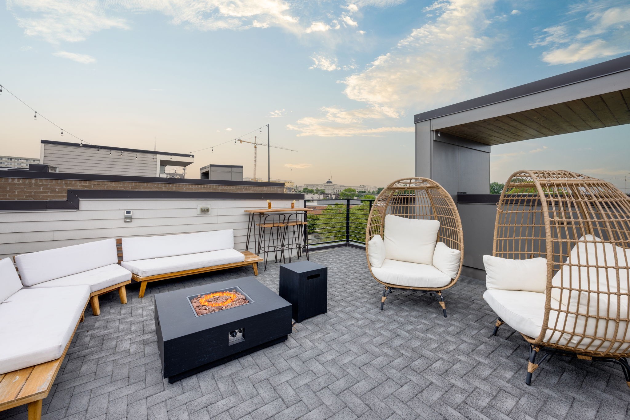 a roof deck with couch and chairs