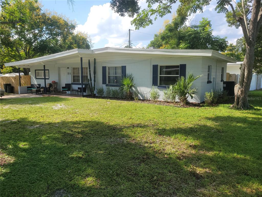 a view of a house with a yard and sitting area