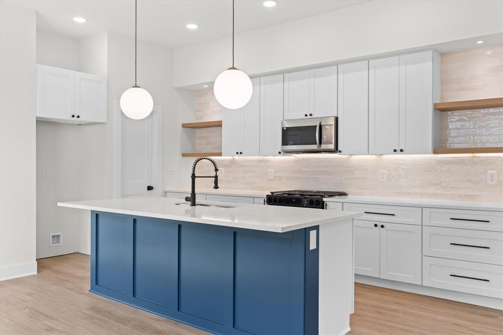 a kitchen with cabinets a sink and stainless steel appliances