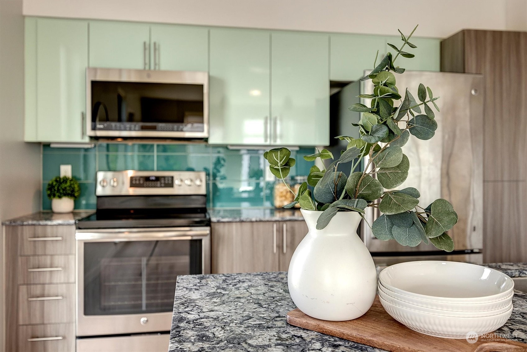 a bathroom with a sink a microwave and potted plant