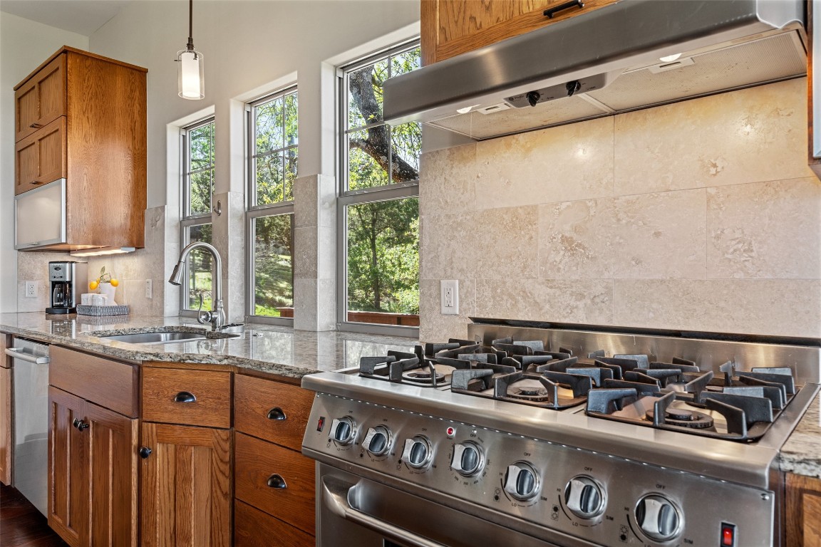 a kitchen with granite countertop a sink and a stove