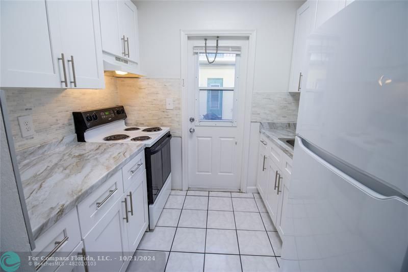 a kitchen with a stove sink and cabinets