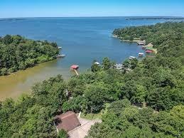 an aerial view of ocean with residential house with outdoor space and trees around