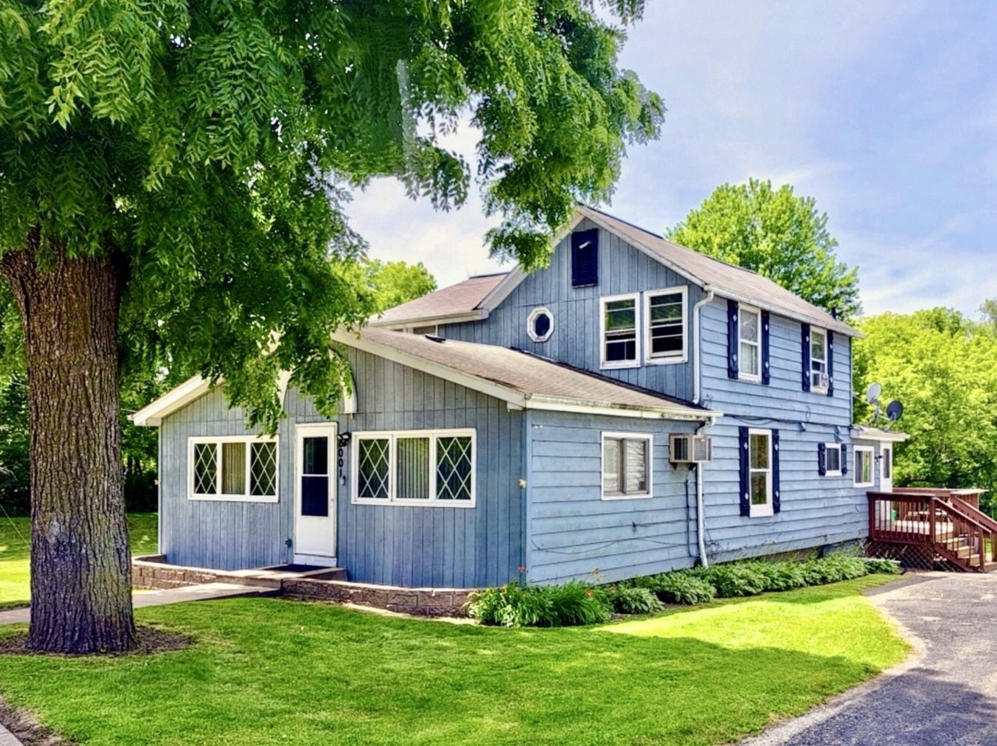 a front view of a house with a yard and trees