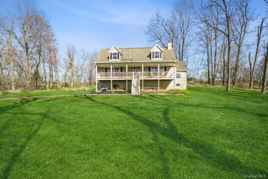 a view of a house with a big yard and large trees