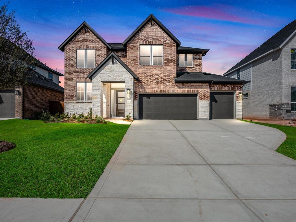 a front view of a house with a yard and garage