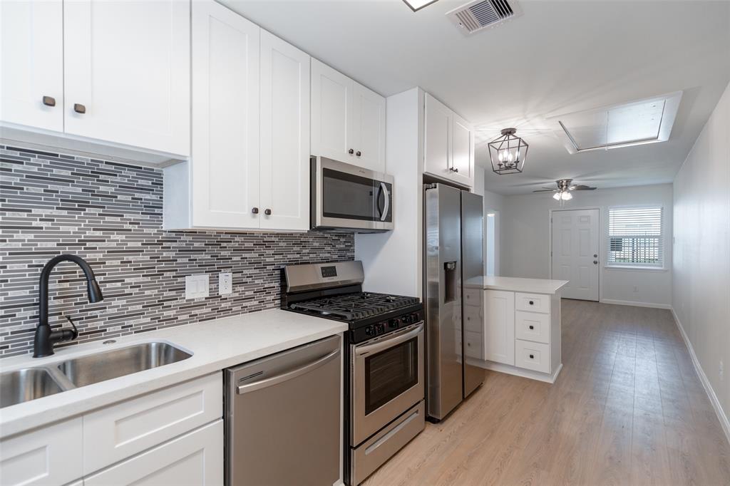 a kitchen with a sink cabinets and stainless steel appliances