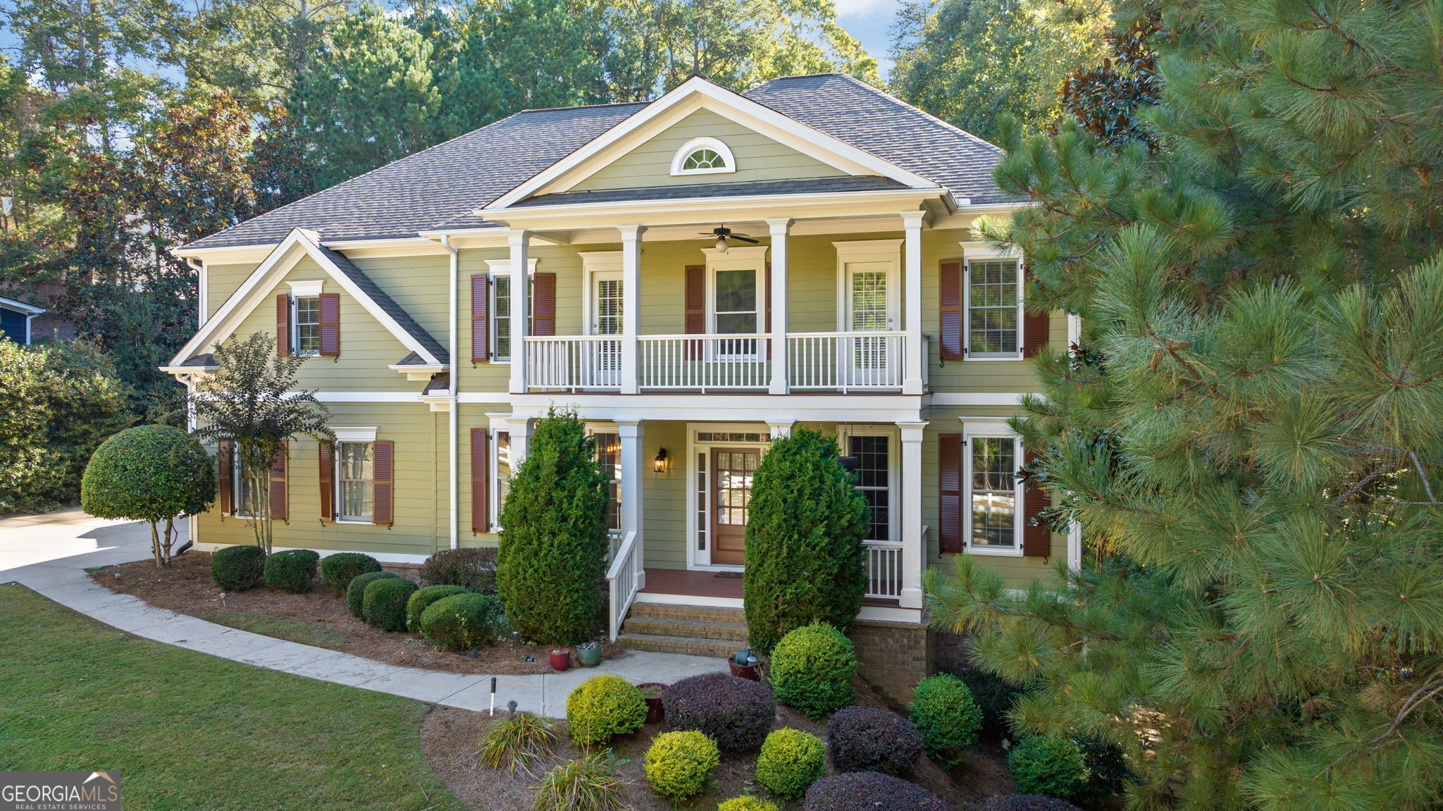 a front view of a house with a yard and potted plants