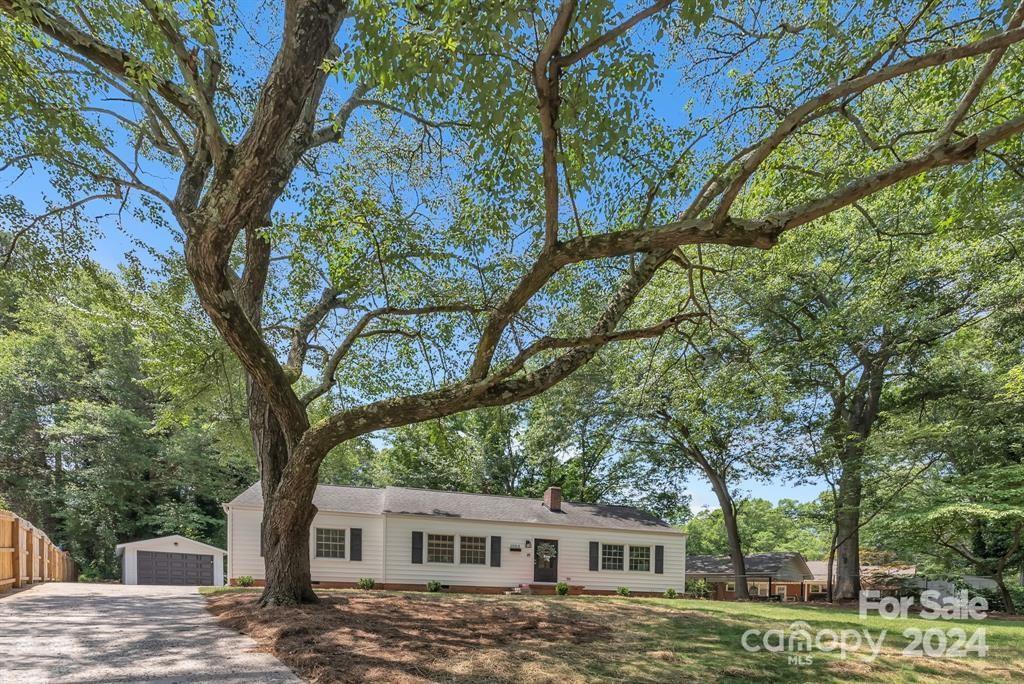 a front view of a house with a tree