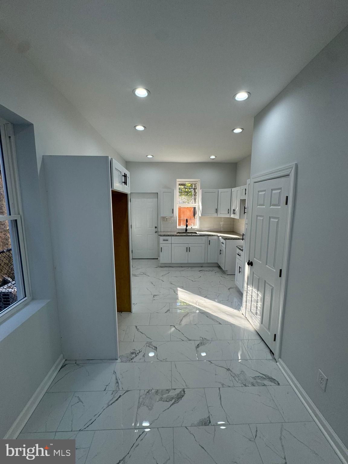 a view of kitchen with refrigerator and window