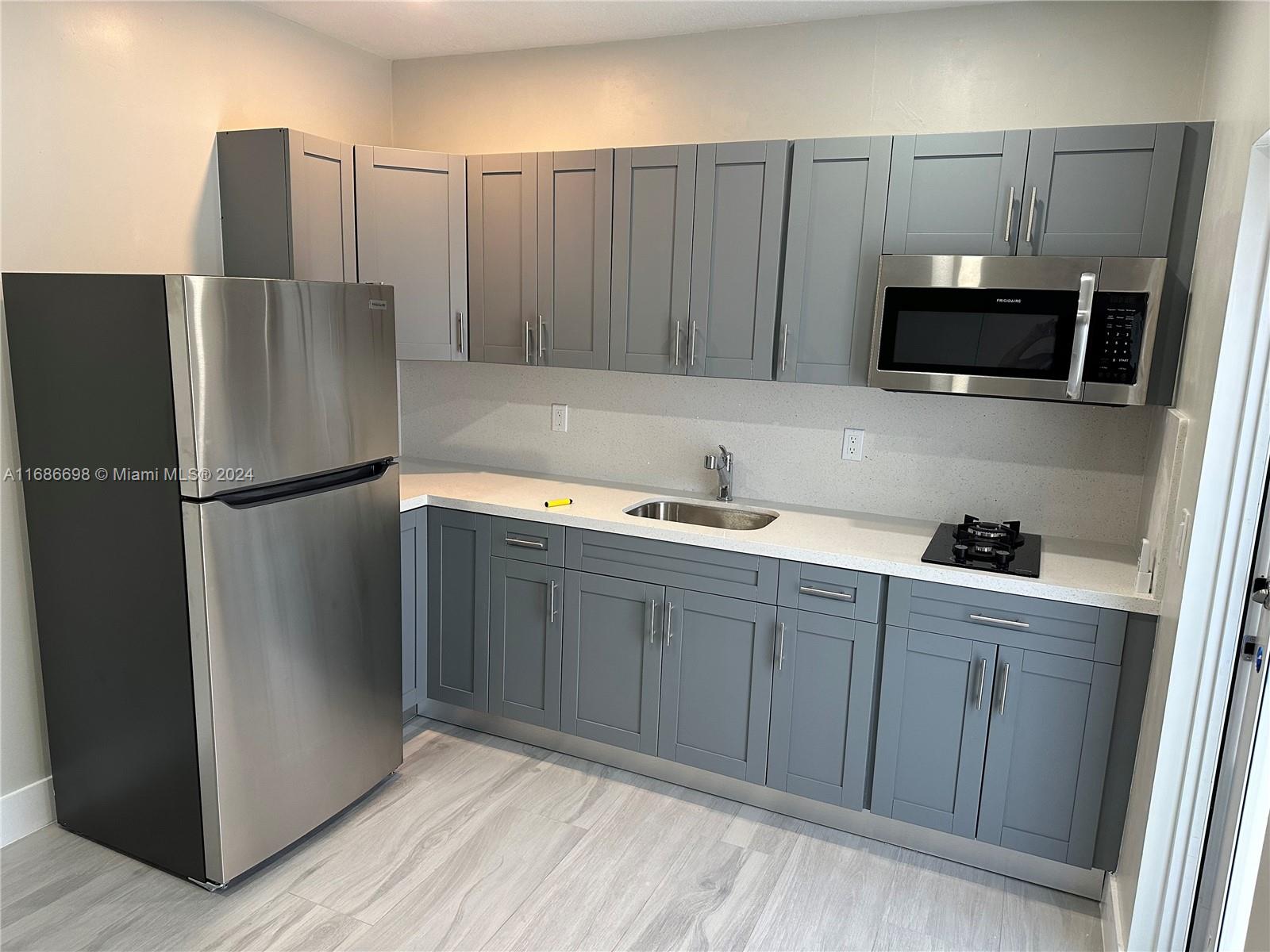 a kitchen with stainless steel appliances granite countertop a refrigerator and a sink