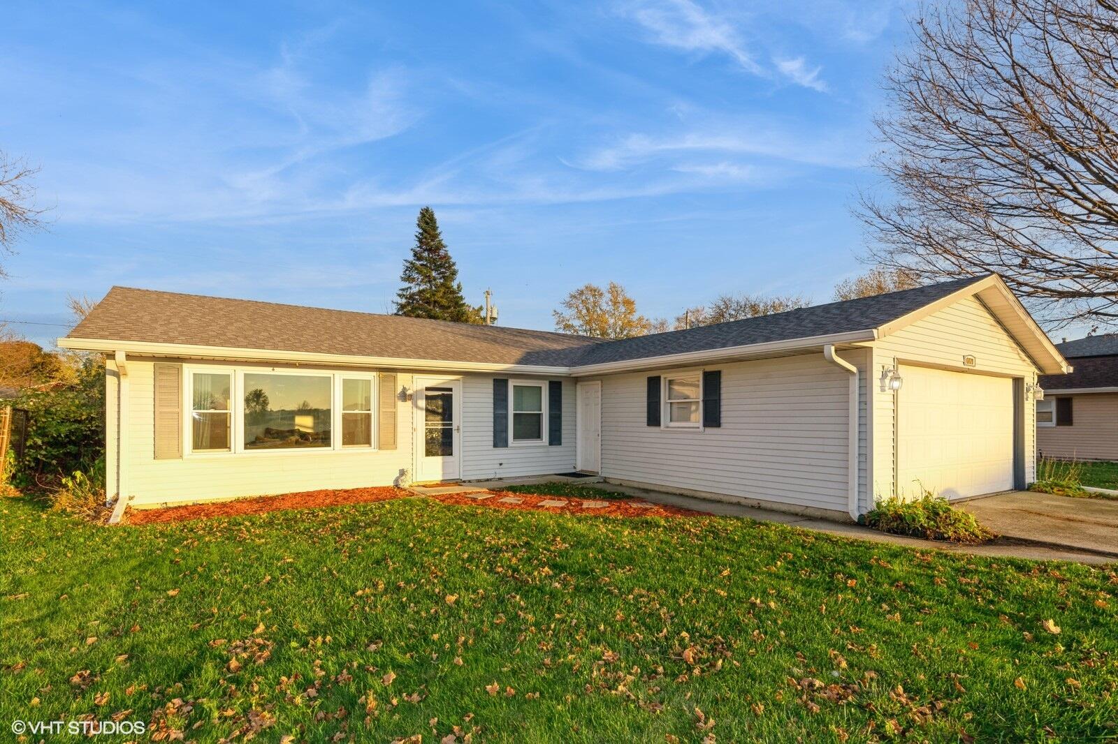 a front view of house with yard and trees around