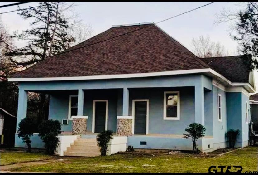 a front view of a house with a garden