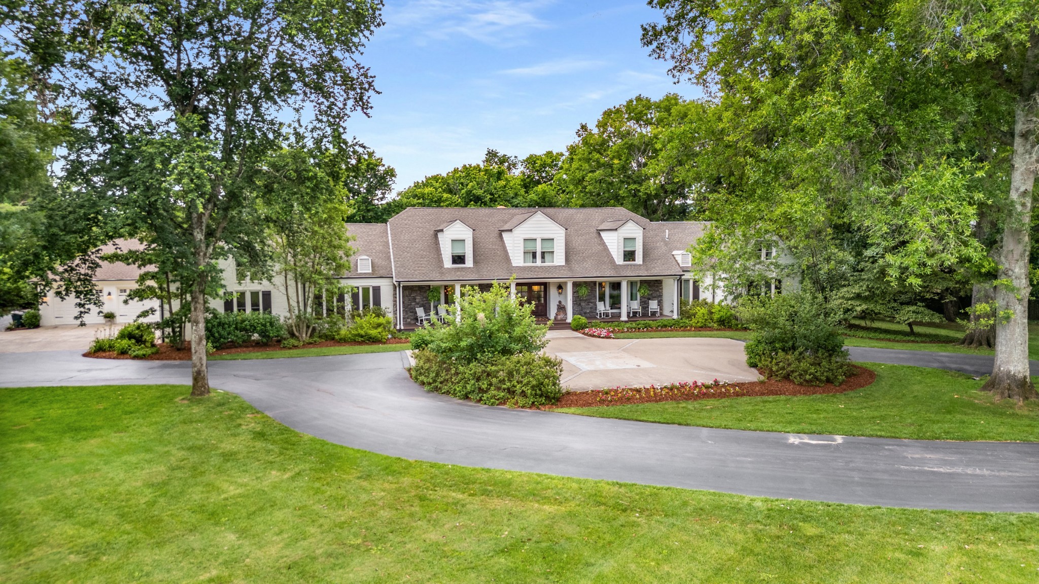 a front view of a house with a garden and yard