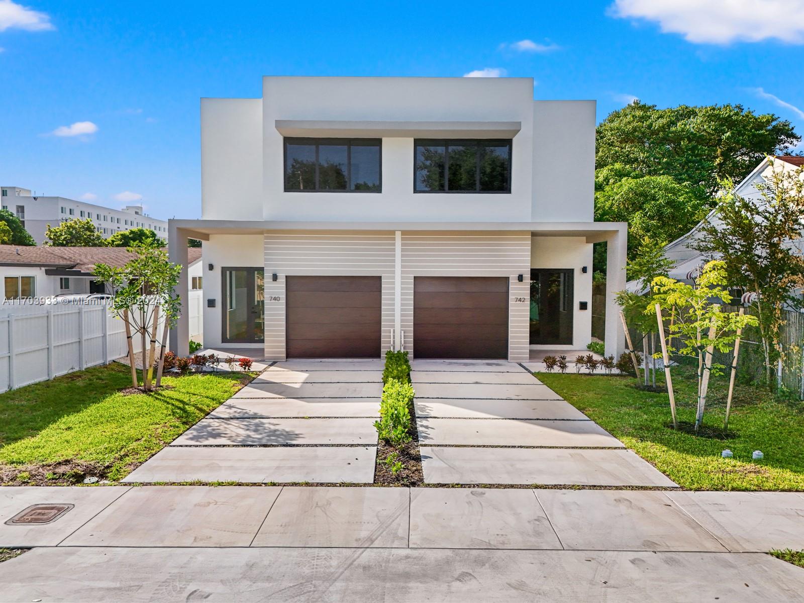 a front view of a house with a garden and yard