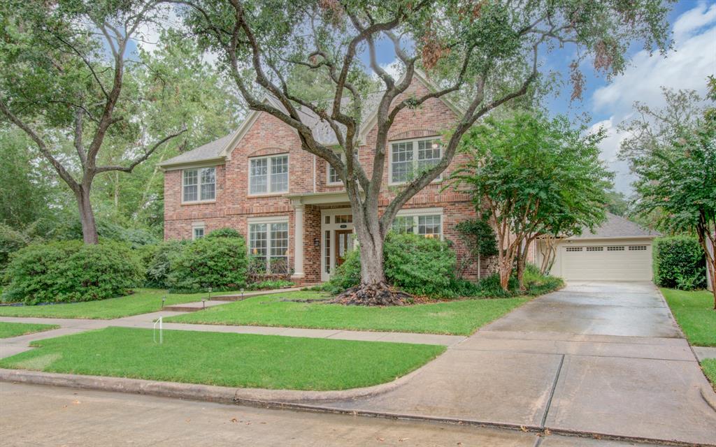 a front view of a house with a yard and trees