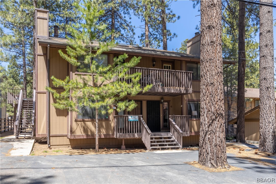 a front view of a house with a tree