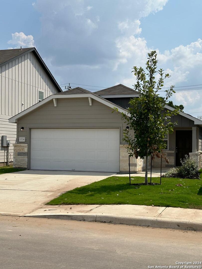 a front view of a house with a garden and trees