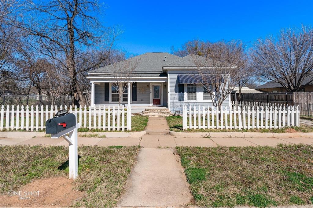 a front view of a house with a yard and fence