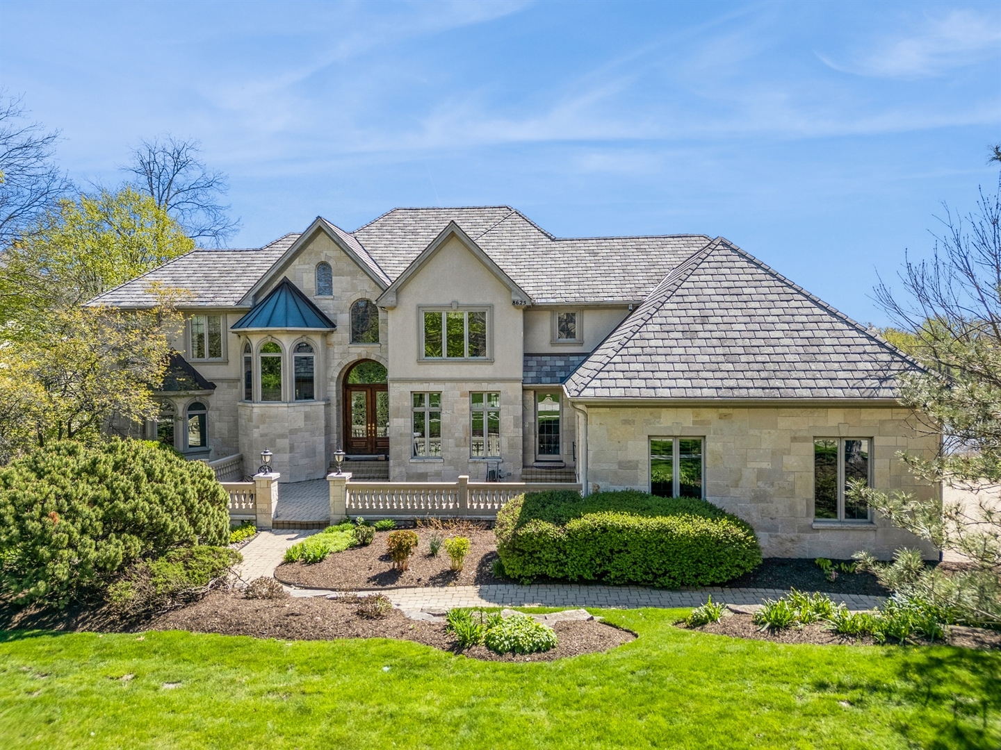 a front view of a house with a garden and plants