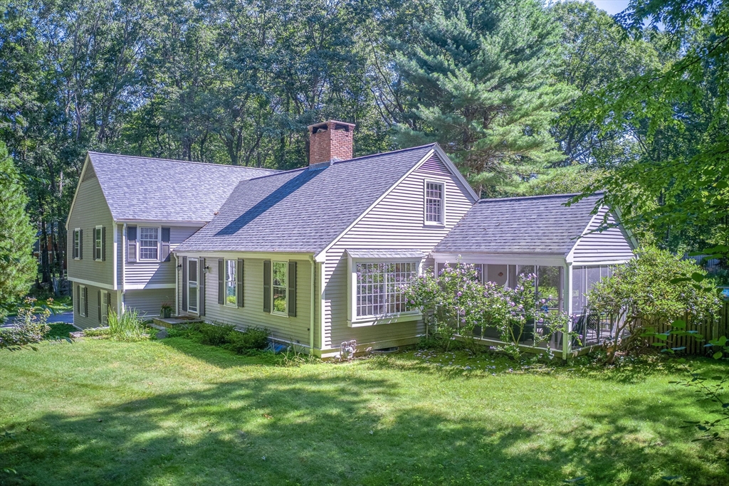 a view of a house with a big yard plants and large trees