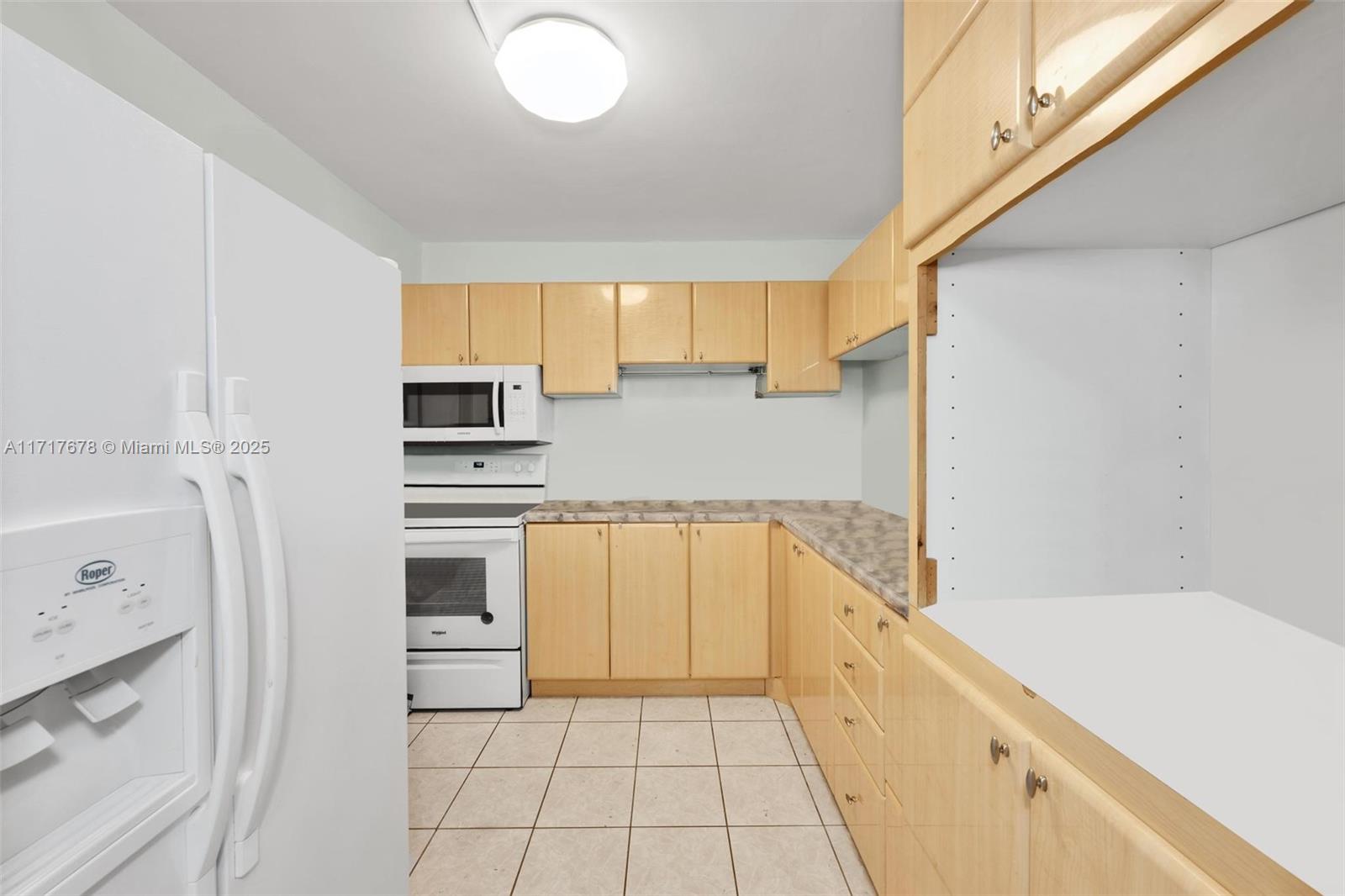 a kitchen with granite countertop white cabinets and white appliances