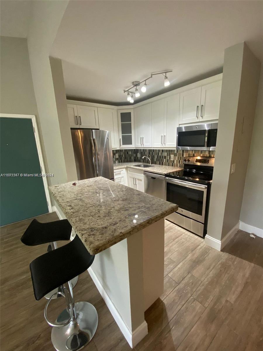 a kitchen with sink cabinets and stainless steel appliances